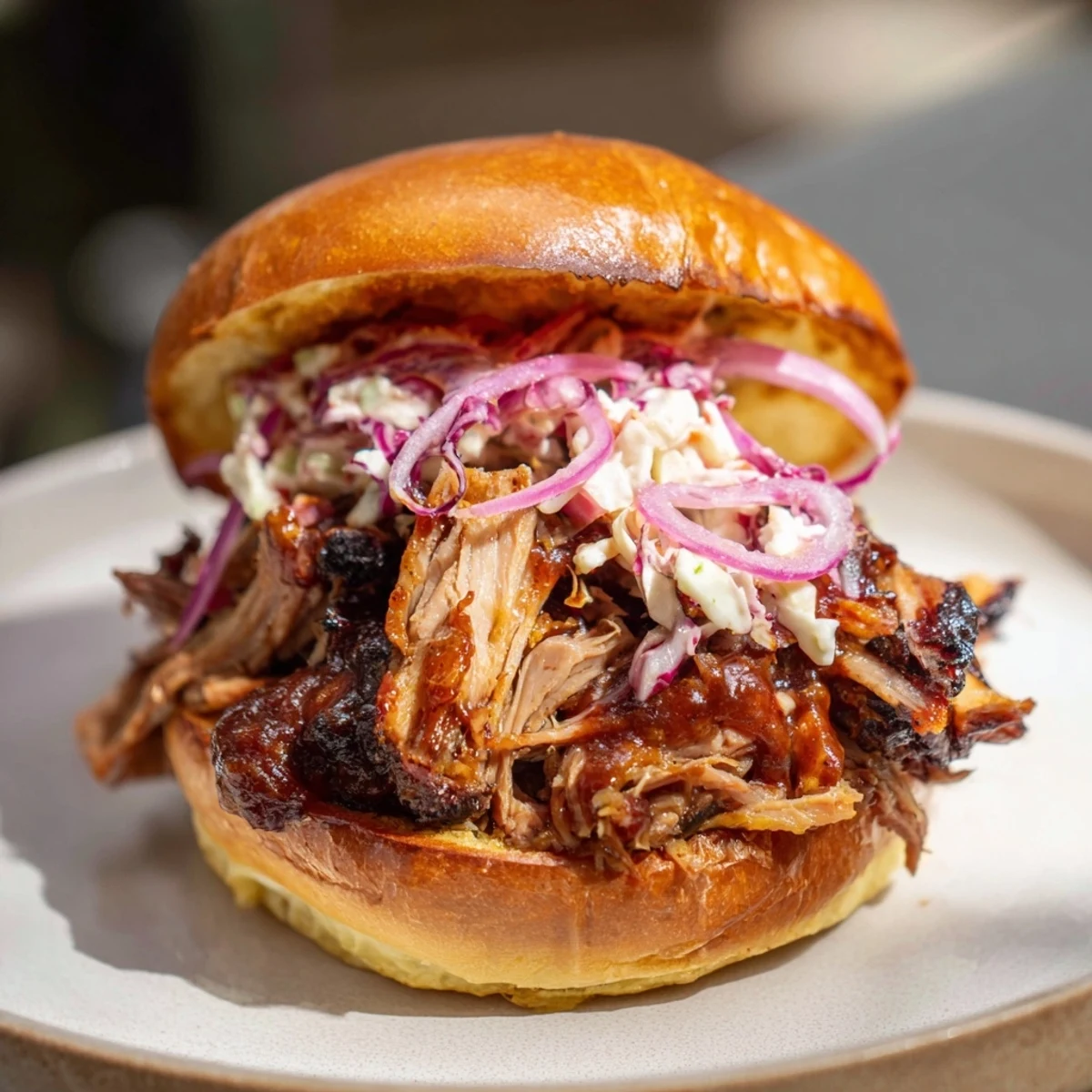 Enjoy the tempting textures of Fire-Kissed BBQ Pulled Pork Sandwiches; a hearty American meal with smoky flavor profiles.
