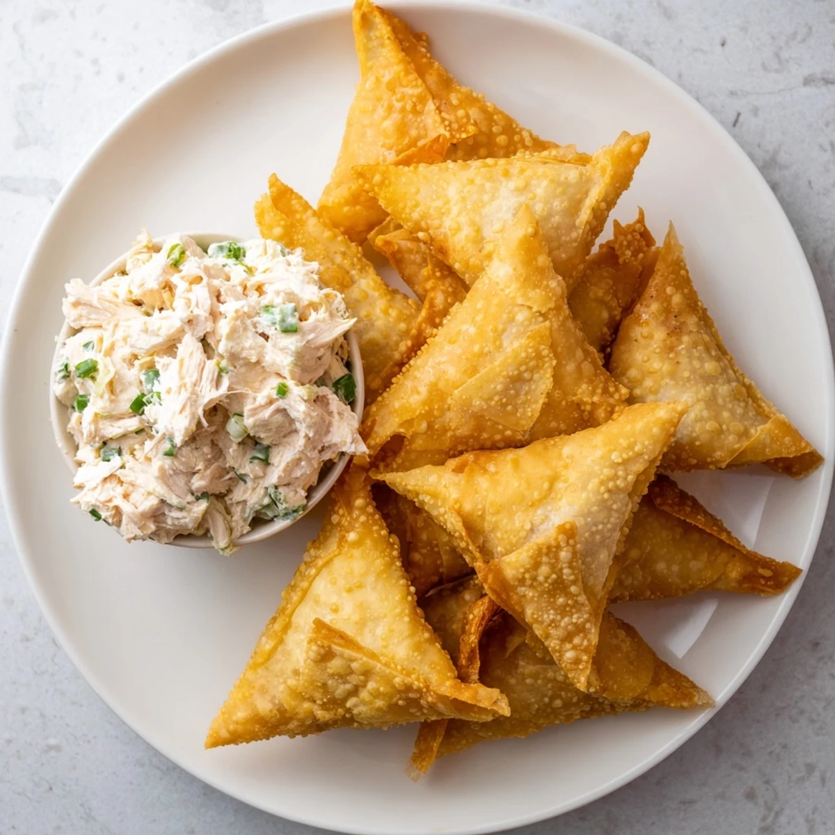 Golden air fryer lumpia chips alongside creamy chicken cream cheese dip, a delicious Filipino appetizer.