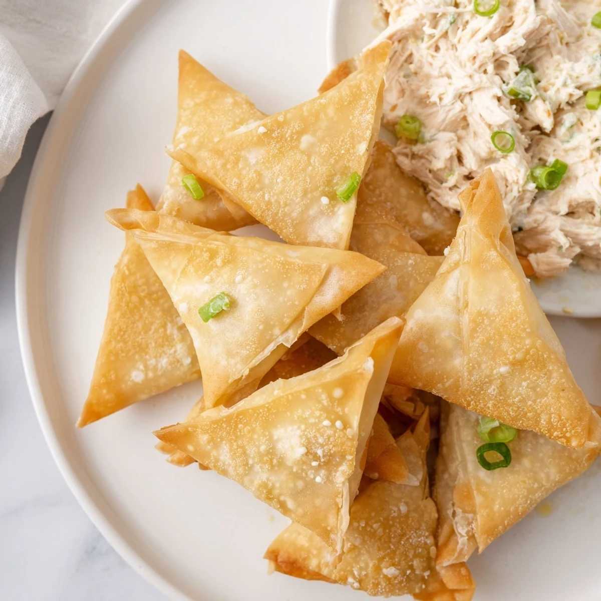 Perfectly crispy and golden brown air fryer lumpia chips ready to dip into chicken cream cheese goodness.