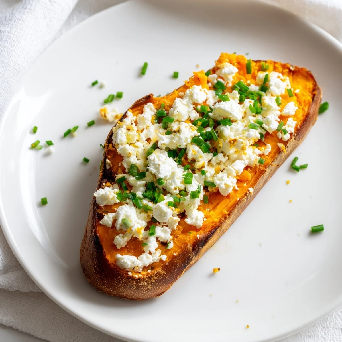 Crispy roasted sweet potato slices topped with creamy avocado, sliced cherry tomatoes, and fresh chives.  