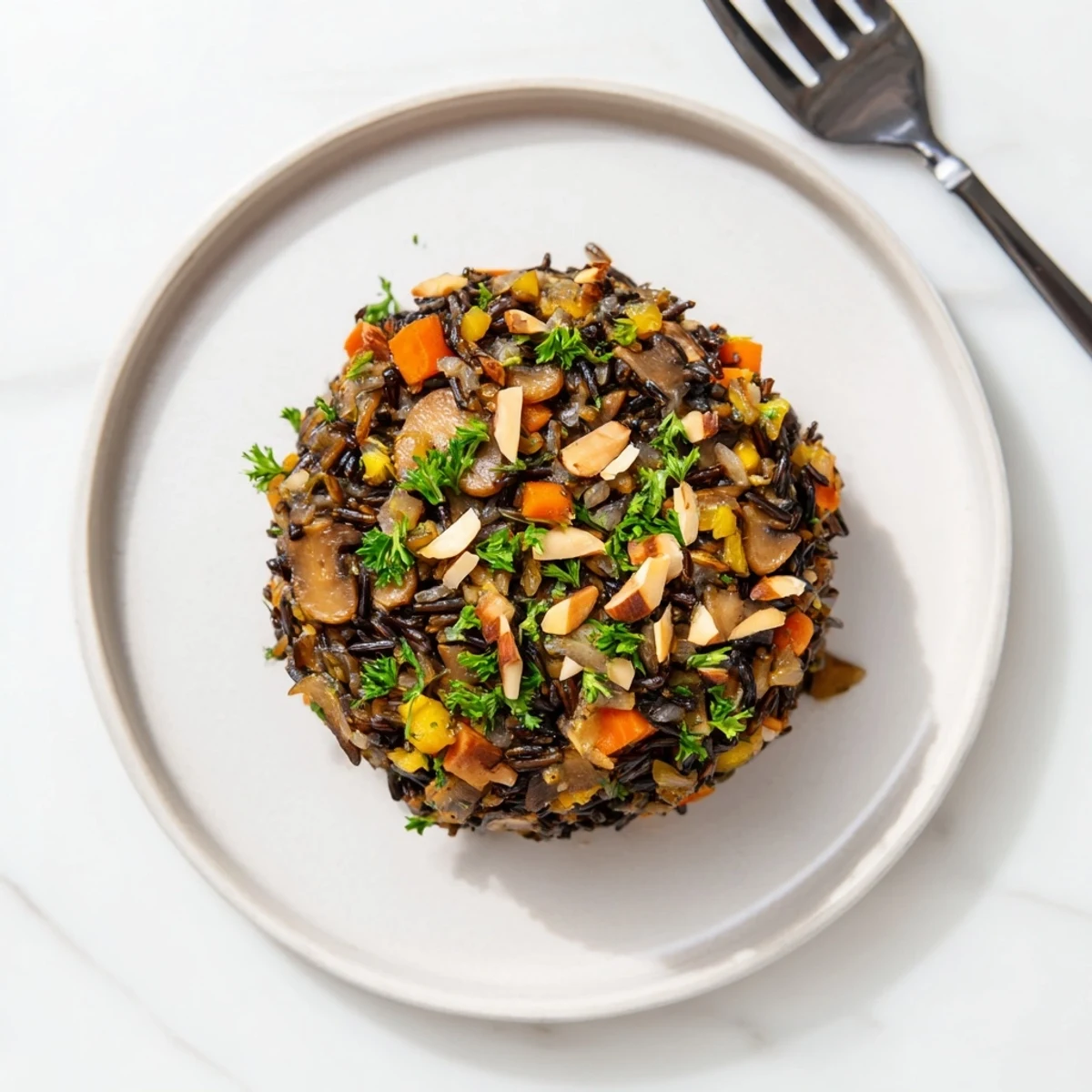 Hearty Wild Rice and Mushroom Pilaf with golden sautéed mushrooms, carrots, and celery, ready to serve.  