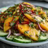 Refreshing Mango Salad with Lime Dressing served in a white bowl with a lime wedge, ideal for a light lunch.