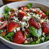 Fresh strawberry spinach salad with poppyseed dressing, featuring sweet berries, tender greens, and crunchy nuts in a creamy homemade dressing.