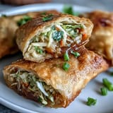A platter of crispy spring rolls served with creamy peanut dipping sauce, perfect for appetizers or light meals.  