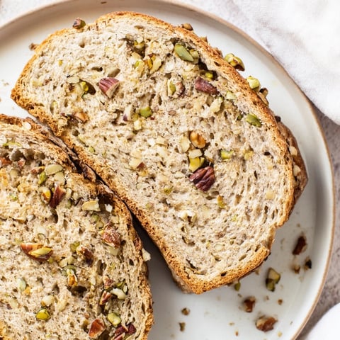 Golden, crusty Nutty Whole Wheat Loaf Bread, freshly baked, ready to slice for a treat.