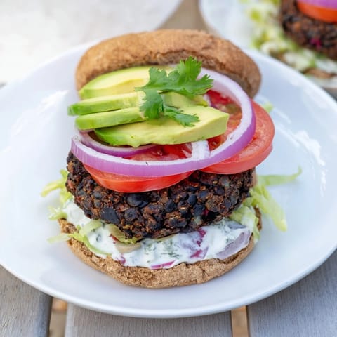 A close-up shot of grilled Zesty Black Bean Burgers reveals vibrant colors and fresh toppings.