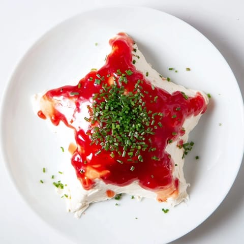 A creamy Cream Cheese and Pepper Jelly Star, ready to be served with crackers at your holiday party.