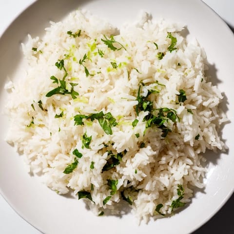 A vibrant bowl of cilantro lime rice, with flecks of green, offering a bright, zesty aroma.