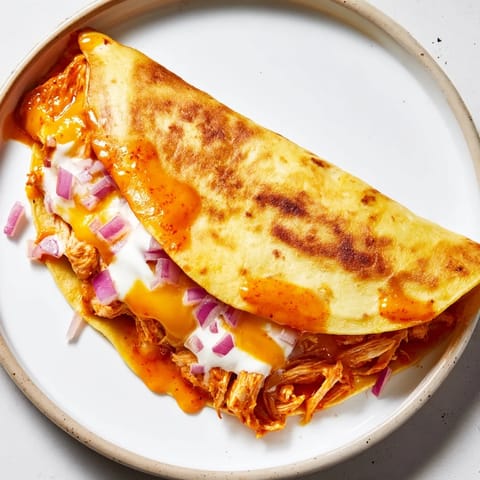 A close-up shot of a Buffalo Chicken Quesadilla, showcasing melty cheese and the flavorful chicken filling.