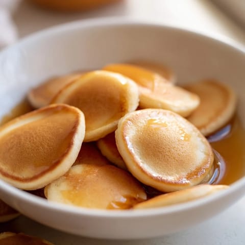 Warm, bite-sized Fluffy Pancake Cereal ready to eat, served with cold milk for a treat.