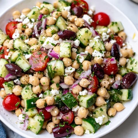 Vibrant Mediterranean Chickpea Salad with juicy tomatoes, olives, and a zesty lemon dressing.