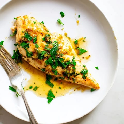 Freshly chopped parsley garnishes this sizzling Lemon Pepper Chicken, served alongside fluffy white rice and steamed green beans.