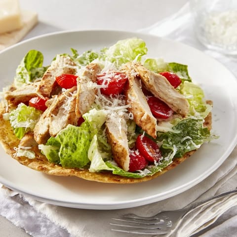 Caesar Chicken Flatbread with crisp lettuce and Parmesan, served warm with lemon wedges.  