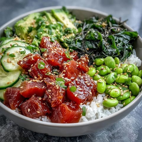 Spicy tuna poke bowl with marinated sushi-grade tuna, avocado, and cucumber over seasoned rice.  