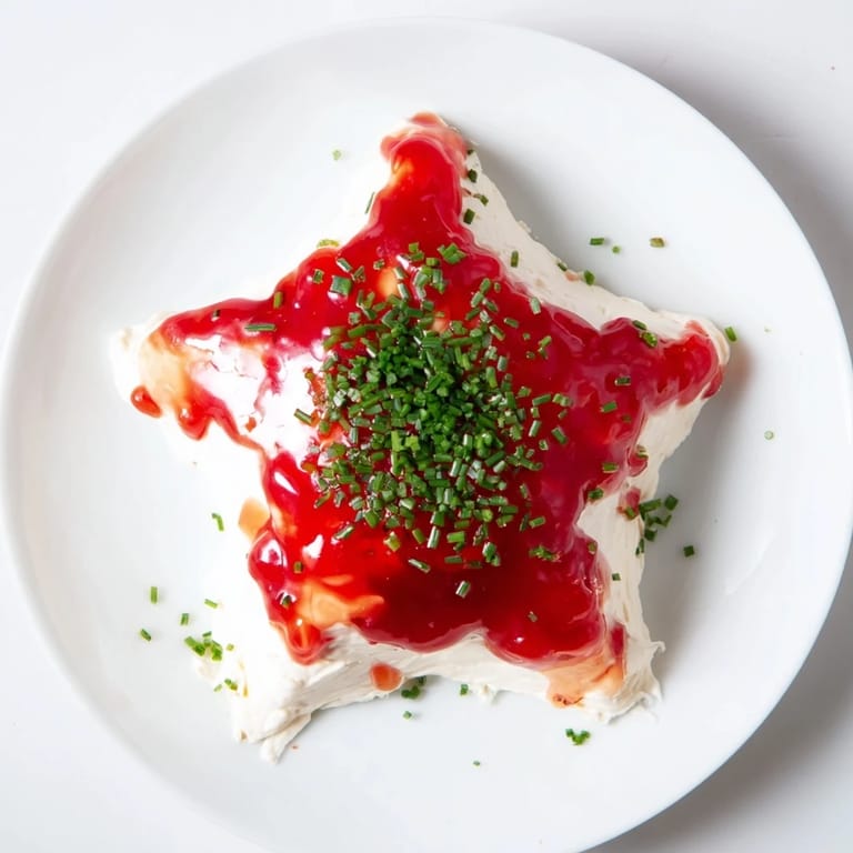 A creamy Cream Cheese and Pepper Jelly Star, ready to be served with crackers at your holiday party.