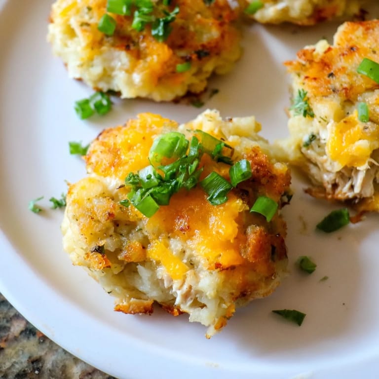 Plated Potato and Chicken Cakes, garnished with fresh parsley, offer a delightful taste of classic comfort food ready to eat.